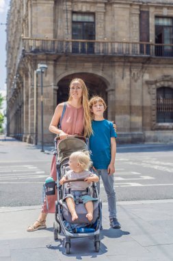 Annesi, küçük oğlu ve genç oğlu Mexico City, Zocalo 'nun merkez meydanında turistler. Aile seyahati, kültürel keşif ve tarihi mimari konsepti..