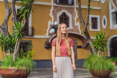 Puebla, Meksika 'nın renkli koloni sokaklarında yürüyen kadın turist. Seyahat, kültürel keşif ve canlı mimari konsepti..