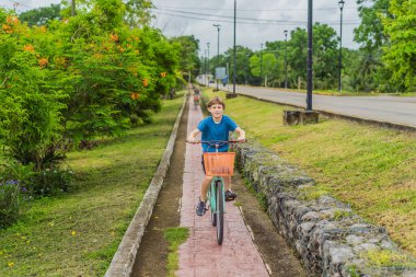 Erkek turist Meksika 'nın Bacalar köyünde bisiklet sürüyor. Quintana Roo seyahati, manzaralı bisiklet yolları ve çevre dostu keşif konsepti..