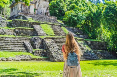 Female tourist exploring the ancient pyramids of Palenque, Mexico, surrounded by dense jungle. Cultural heritage and adventure travel concept. clipart