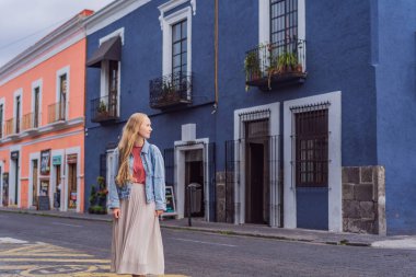Puebla, Meksika 'nın renkli koloni sokaklarında yürüyen kadın turist. Seyahat, kültürel keşif ve canlı mimari konsepti..