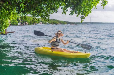 Meksika 'da Bacalar Gölü' nde kayak yapan bir kadın. Quintana Roo 'da macera turizmi, açık hava keşfi ve su aktiviteleri konsepti.