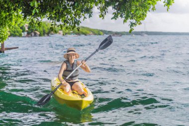 Meksika 'da Bacalar Gölü' nde kayak yapan bir kadın. Quintana Roo 'da macera turizmi, açık hava keşfi ve su aktiviteleri konsepti.