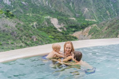 Anne ve çocukları Grutas Tolantongo, Meksika 'nın kaplıcalarında banyo yapıyorlar. Aile macerası, rahatlama ve doğal sağlık konsepti..