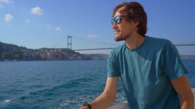Genç adam, Boğaz boyunca bir teknede seyahat ederken manzaranın tadını çıkarıyor. Martıları ekmek parçalarıyla besliyor. Manzaralı seyahat, vahşi yaşam etkileşimi ve macera konsepti.