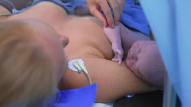 Cerrah sezaryen ameliyatını tamamlarken yeni doğmuş bir bebek anne göğsüne yerleştirilir. Annelik bağı, aşk ve doğumdan sonraki ilk kucaklaşma.