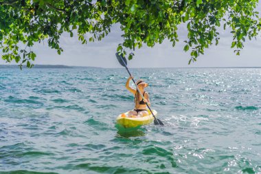 Meksika 'da Bacalar Gölü' nde kayak yapan bir kadın. Quintana Roo 'da macera turizmi, açık hava keşfi ve su aktiviteleri konsepti.