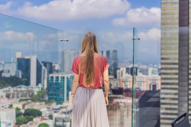 Kadın turist ya da iş kadını, Mexico City manzaralı bir gökdelenin çatısında dikiliyor. Meksika konseptinde seyahat ya da uluslararası iş.