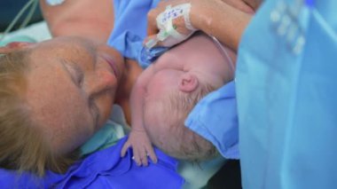 Cerrah sezaryen ameliyatını tamamlarken yeni doğmuş bir bebek anne göğsüne yerleştirilir. Annelik bağı, aşk ve doğumdan sonraki ilk kucaklaşma.