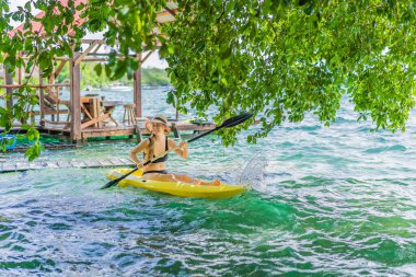 Meksika 'da Bacalar Gölü' nde kayak yapan bir kadın. Quintana Roo 'da macera turizmi, açık hava keşfi ve su aktiviteleri konsepti.