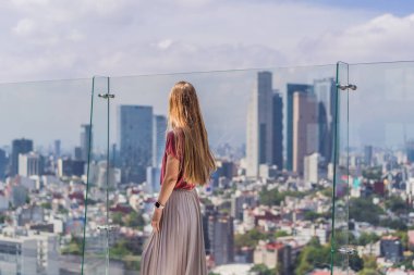 Kadın turist ya da iş kadını, Mexico City manzaralı bir gökdelenin çatısında dikiliyor. Meksika konseptinde seyahat ya da uluslararası iş.