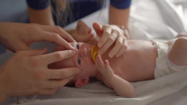 Yeni doğmuş bir bebek ve annesi bir osteopattan sağlık kontrolü ve olası sorunlara karşı nazik bir terapi görürler. Bebek sağlığına, refahına ve erken gelişime odaklanmış bir an.