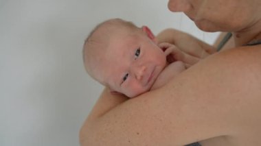 Genç bir anne sevgiyle kucağında küçük bebeğini kucağına alır. Yürek ısıtan bir bağ ve şefkat anını paylaşır. Aşkın güzel bir ifadesi, bağlanma ve anneliğin başlangıcı.