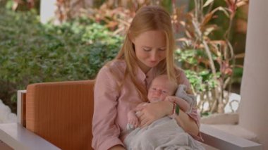 Bir anne ve yeni doğan bebeği, tropik bir sahil beldesinde güneşli bir günün tadını çıkarıyorlar. Tropiklerin sıcaklığı ve güzelliği ile çevrili huzurlu bir bağ, rahatlama ve aile zamanı..