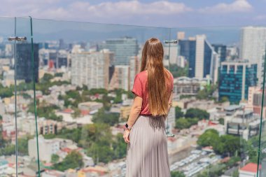 Kadın turist ya da iş kadını, Mexico City manzaralı bir gökdelenin çatısında dikiliyor. Meksika konseptinde seyahat ya da uluslararası iş.