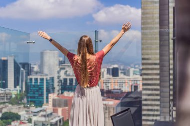 Kadın turist ya da iş kadını, Mexico City manzaralı bir gökdelenin çatısında dikiliyor. Meksika konseptinde seyahat ya da uluslararası iş.