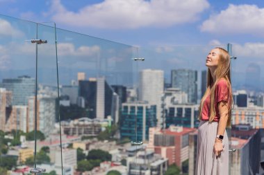 Kadın turist ya da iş kadını, Mexico City manzaralı bir gökdelenin çatısında dikiliyor. Meksika konseptinde seyahat ya da uluslararası iş.