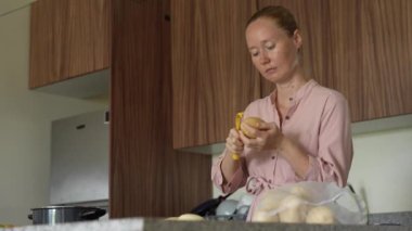 Genç bir kadın mutfakta yemek pişiriyor ve lezzetli bir ev yemeği hazırlamaya odaklanıyor. Sıcacık bir ortamda ev yapımı, yaratıcılık ve aşçılık keyfi.