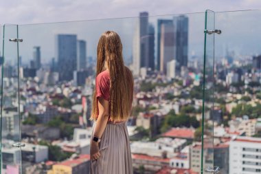 Kadın turist ya da iş kadını, Mexico City manzaralı bir gökdelenin çatısında dikiliyor. Meksika konseptinde seyahat ya da uluslararası iş.