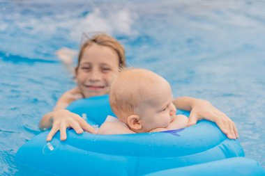 Bir ağabeyi, şişme bir şamandırada güvenli bir şekilde oturan küçük kardeşiyle birlikte havuzda yüzer. Gülme, kaynaşma ve yaz eğlenceleriyle dolu neşeli bir aile anı. Çocukluk, ilgi ve kardeş