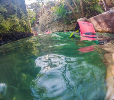09.12.24, Playa Del Carmen, Meksika: Xcaret parkındaki bir mezarlıkta işaretli can yeleği giyen erkek turist. Doğal parklarda Meksika turizmi. Macera, çocukluk keşfi ve eko