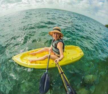 Meksika, Bacalar Gölü 'nün sakin turkuaz sularında doğal güzelliklerle çevrili değişmemiş bir turist kanosu. Barışçıl bir tropikal ortamda macera, rahatlama ve açık hava seyahati kavramı