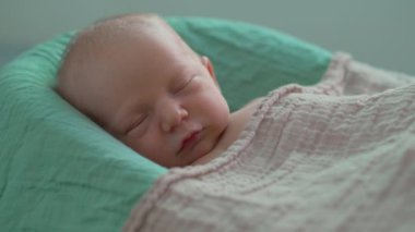 Yeni doğmuş bir bebek, yumuşak çarşafla örtülü, rahat bir bebek kozasında huzur içinde yatar. Huzurlu ve rahat bir an. Bebeklerin ilk günleri için rahatlık ve ilgiyi ön plana çıkarıyor.