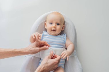 Sevimli 3 aylık bebek güvenli bir şekilde emniyet kemeriyle güvenli bir bebek kozasında yatıyor. Yeni doğan bakımı için rahat ve koruyucu tasarım. Ebeveynlik, güvenlik ve bebek konforu.