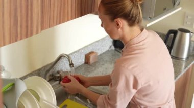 Genç bir kadın mutfakta yemek pişiriyor ve lezzetli bir ev yemeği hazırlamaya odaklanıyor. Sıcacık bir ortamda ev yapımı, yaratıcılık ve aşçılık keyfi.