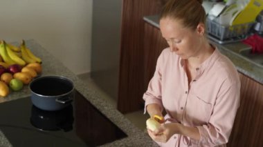 Genç bir kadın mutfakta yemek pişiriyor ve lezzetli bir ev yemeği hazırlamaya odaklanıyor. Sıcacık bir ortamda ev yapımı, yaratıcılık ve aşçılık keyfi.