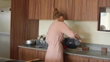 Genç bir kadın mutfakta yemek pişiriyor ve lezzetli bir ev yemeği hazırlamaya odaklanıyor. Sıcacık bir ortamda ev yapımı, yaratıcılık ve aşçılık keyfi.