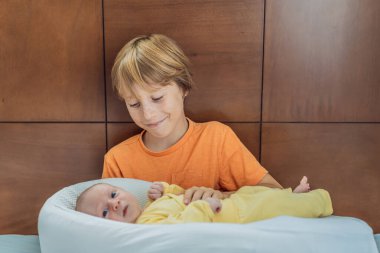 Genç bir çocuk sevgiyle yeni doğan erkek kardeşini sıcak bir uyku kozasında kucaklıyor, hassas bir kardeş anını paylaşıyor. Yürek ısıtan bir aile bağı, koruma ve kardeşçe bir ilişkinin başlangıcı.