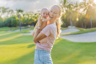 Genç anne, bir aylık bebeğiyle parkta huzurlu bir yürüyüşün tadını çıkarıyor. Annelik, bağlılık ve açık hava aile zaman kavramı..