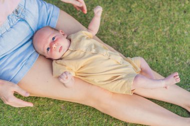 Genç anne, bir aylık bebeğiyle parkta huzurlu bir yürüyüşün tadını çıkarıyor. Annelik, bağlılık ve açık hava aile zaman kavramı..