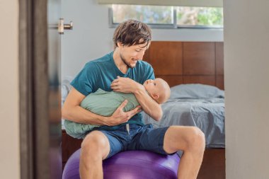 A father sits on a fitness ball in a cozy bedroom, gently rocking his baby wrapped in a soft muslin swaddle. A nurturing and soothing moment of fatherhood and care. Parenting, bonding, and comfort clipart