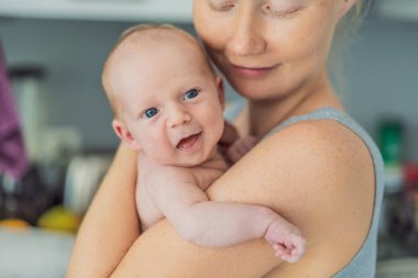 Bir anne sevgiyle yeni doğmuş bebeğini kucaklar, onları göğsüne yakın tutar. Yumuşak bir sıcaklık, güven ve derin anne sevgisi. Bağlanmayı, rahatlığı ve kırılmaz bağı sembolize ediyor.