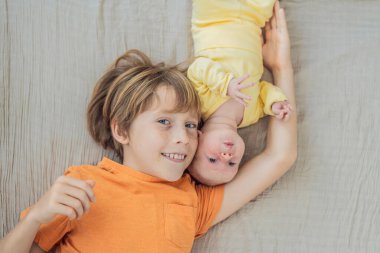 Genç bir çocuk ve yeni doğan erkek kardeşi yumuşak bir muslin battaniyeye uzanıp kardeşçe bir anı paylaşıyorlar. Yürek ısıtan bir kardeş sevgisi, bağlılık ve hayat boyu sürecek bir bağlantının başlangıcı..