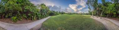 Bereketli ormanlarla çevrili tropikal bir golf sahasının manzarası. Sakin manzara rahatlama, spor ve lüks seyahat için idealdir. Doğa, eğlence ve tropikal kaçış konsepti.