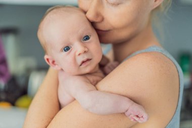 Bir anne sevgiyle yeni doğmuş bebeğini kucaklar, onları göğsüne yakın tutar. Yumuşak bir sıcaklık, güven ve derin anne sevgisi. Bağlanmayı, rahatlığı ve kırılmaz bağı sembolize ediyor.
