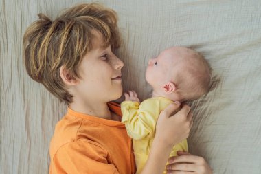 Genç bir çocuk ve yeni doğan erkek kardeşi yumuşak bir muslin battaniyeye uzanıp kardeşçe bir anı paylaşıyorlar. Yürek ısıtan bir kardeş sevgisi, bağlılık ve hayat boyu sürecek bir bağlantının başlangıcı..
