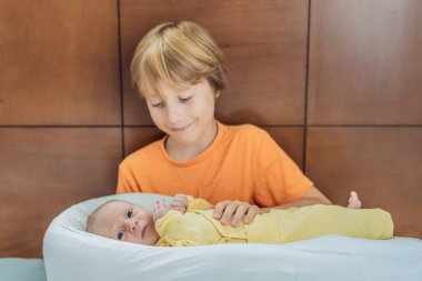 Genç bir çocuk sevgiyle yeni doğan erkek kardeşini sıcak bir uyku kozasında kucaklıyor, hassas bir kardeş anını paylaşıyor. Yürek ısıtan bir aile bağı, koruma ve kardeşçe bir ilişkinin başlangıcı.