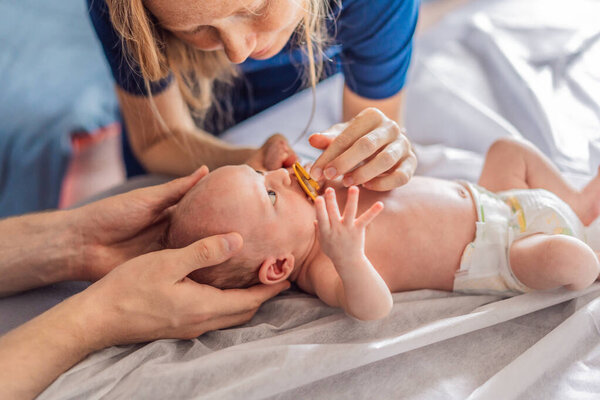 A newborn baby receives gentle osteopathic care, lying calmly while the specialist carefully examines and adjusts the infant. A moment of professional pediatric care, early development, and holistic