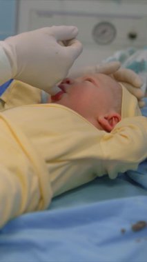 Yeni doğmuş bir bebek, doğumdan hemen sonra bir çocuk doktoru tarafından bir ameliyathanede muayene edilir. Hayatlarının ilk anlarında bebek sağlığını ve refahını sağlamak için dikkatli bir sağlık kontrolü.