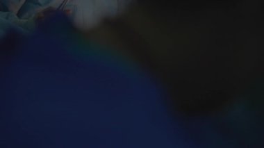 Bir cerrah sezaryen ameliyatının son aşamasında bir kadının karnındaki kesiği dikkatlice diker. Uzmanlığı, annelik bakımını ve