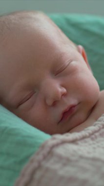 Yeni doğmuş bir bebek, yumuşak çarşafla örtülü, rahat bir bebek kozasında huzur içinde yatar. Huzurlu ve rahat bir an. Bebeklerin ilk günleri için rahatlık ve ilgiyi ön plana çıkarıyor.