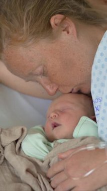 Genç bir kadın hastane yatağında, yanında yeni doğmuş çocuğuyla yatıyor. Hassas ve duygusal bir bağ kurma, aşk ve klinik ortamda anneliğin başlangıcı.