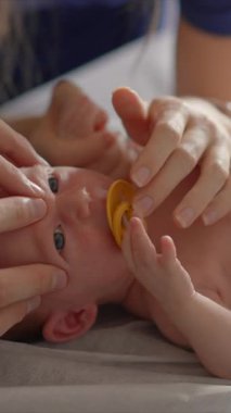 Yeni doğmuş bir bebek ve annesi bir osteopattan sağlık kontrolü ve olası sorunlara karşı nazik bir terapi görürler. Bebek sağlığına, refahına ve erken gelişime odaklanmış bir an.