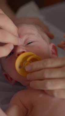 Yeni doğmuş bir bebek ve annesi bir osteopattan sağlık kontrolü ve olası sorunlara karşı nazik bir terapi görürler. Bebek sağlığına, refahına ve erken gelişime odaklanmış bir an.