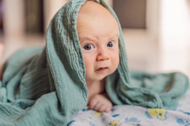 Bir aylık bir bebek karnının üstünde yatıyor ve tuhaf bir şekilde çevreyi gözlemliyor. Boyun dayanıklılığı, bilişsel gelişim ve erken keşif için bebek midesi zamanı. Ebeveynlik ve yeni doğan büyüme kavramı.