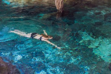 Kadın turist, turkuaz suyla Meksika mezarlığında ferahlatıcı bir yüzüşten zevk alıyor. Macera, seyahat ve doğa keşfi konsepti.